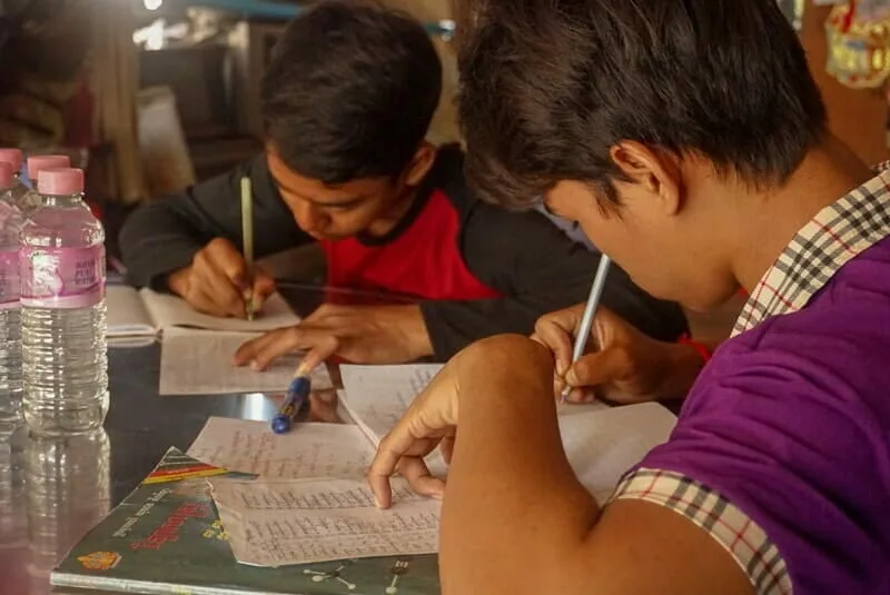 2 boys studying khmer at a table together